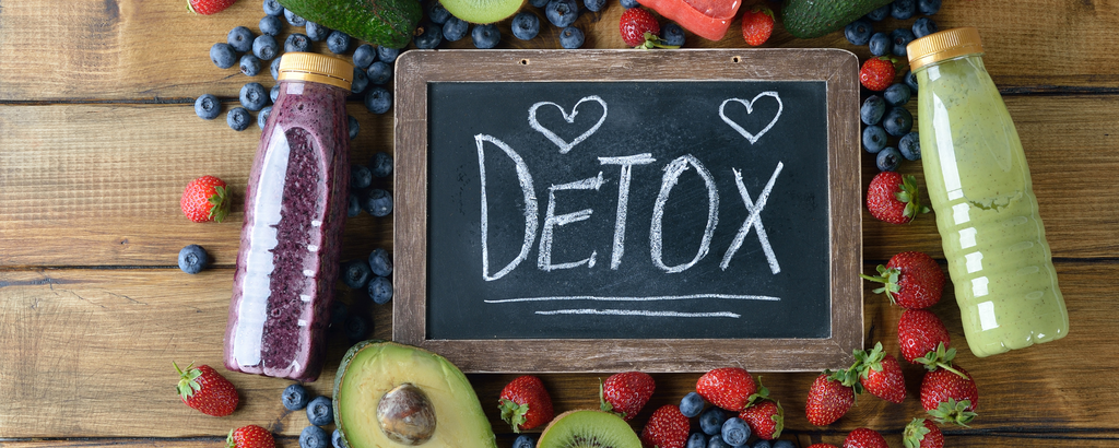 Tafel beschrieben mit Detox und umrandet von Heidelbeeren, Erdbeeren, Kiwis, Avocados und Smoothies