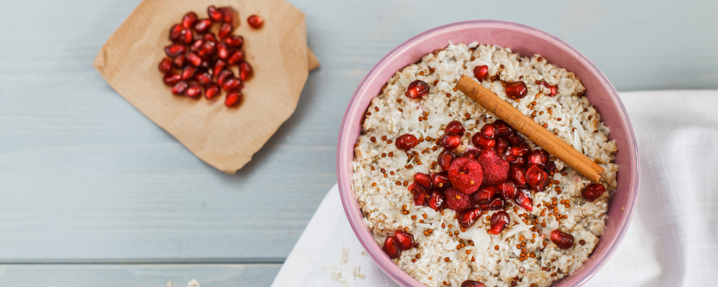 Porridge mit Zimt, Himbeeren und Granatapfelkernen verfeinert